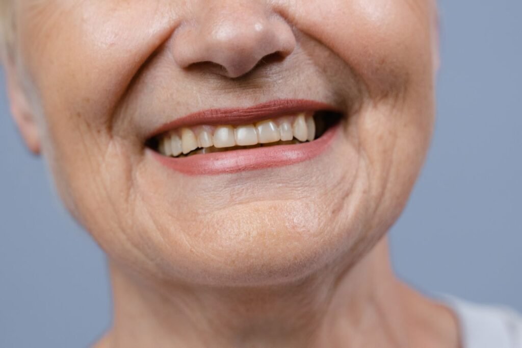 Close-up of a woman smiling with a full, natural-looking upper row of teeth